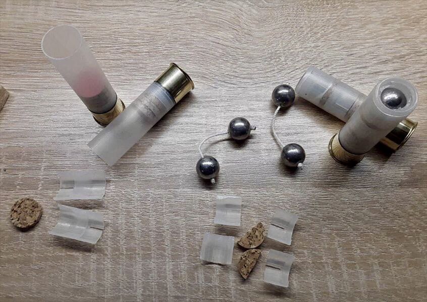 Cartouches de chevrotine liée ouvertes, montrant les billes de plomb reliées par un cordon et les éléments de bourre et de liège.